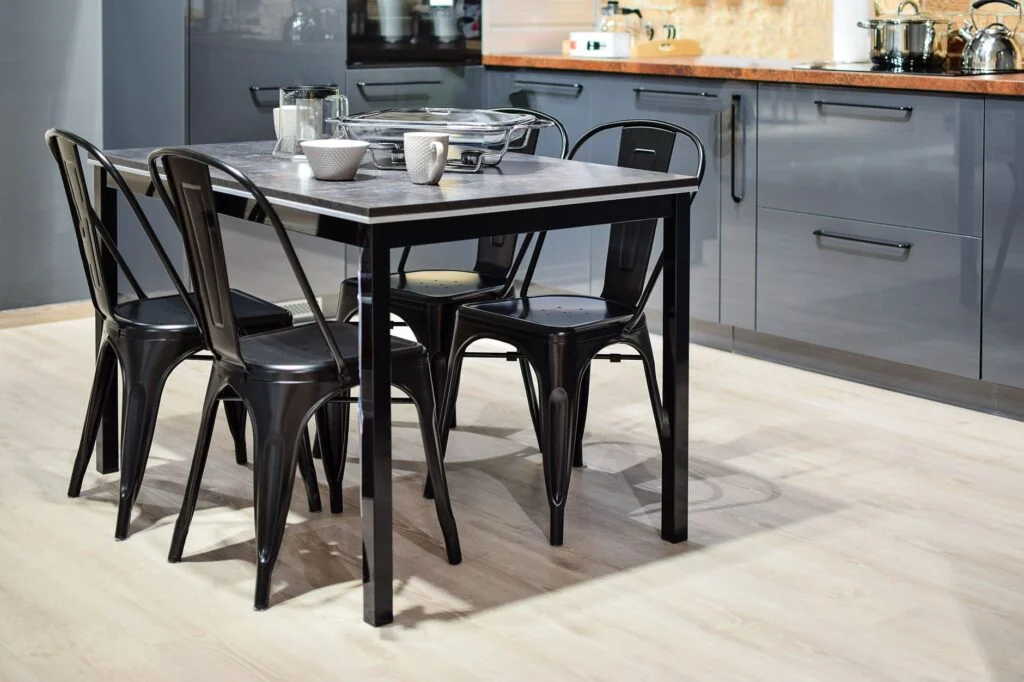 Side-by-side comparison of a modern bamboo dining set and a sleek metal dining set in a contemporary home setting