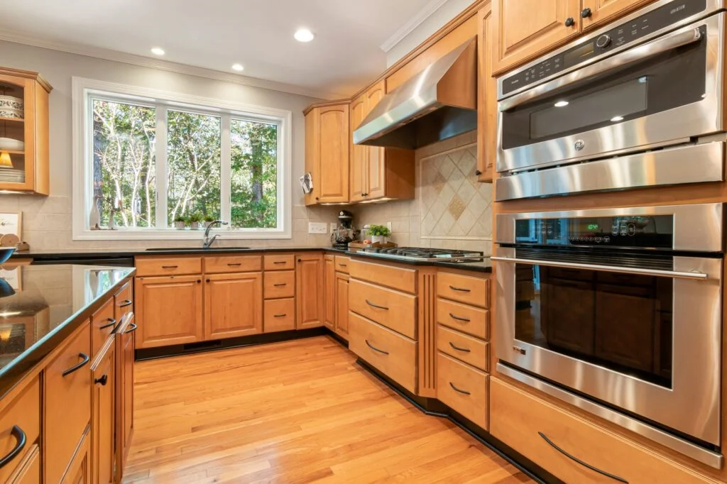 Bamboo kitchen cabinets with natural finish and stainless steel handles